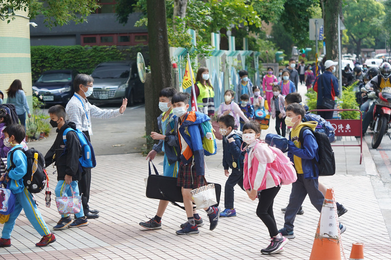 衛福部食藥署已通過授權莫德納疫苗適用於6至11歲兒童，後續實際接種模式及接種時程，須交由衛生福利部傳染病防治諮詢會預防接種組（ACIP）定案。圖為18日台北市北投區國小學生上學情形。 (圖：中央社)