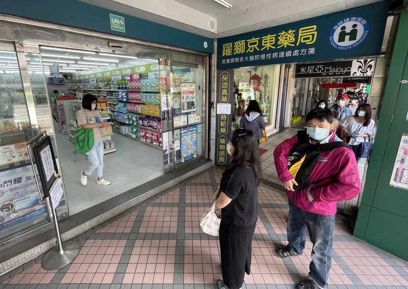 指揮中心放寬確診者同住與密切接觸者打滿三劑疫苗可免隔離政策，立委呼籲需先充實防疫物資。圖為6日松山區民眾在藥局外排隊購買快篩試劑。 (圖：中央社)