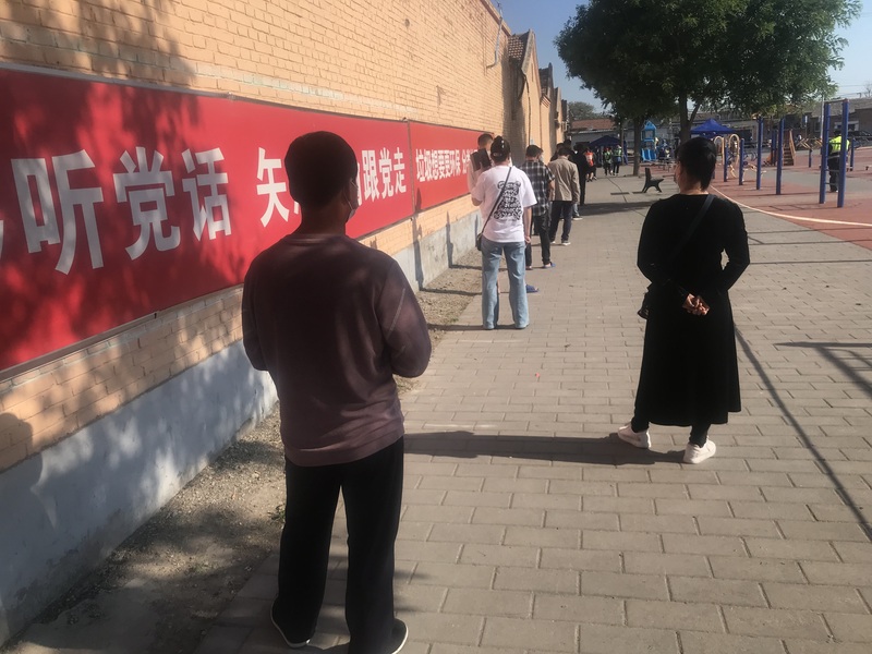 北京以頻繁核酸檢測來防控疫情擴大。圖為15日北京一處核酸檢測點，民眾正排隊等待檢測。 (圖：中央社)