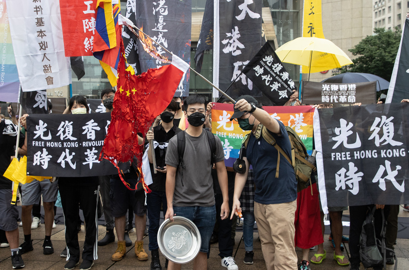 圖為香港邊城青年等團體6月間在台北舉行「612香港行動」，進行「旗海遊行」和「抗爭集會」活動，現場有民眾點火燒五星旗。 (圖：中央社檔案照片)