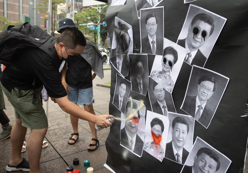 圖為香港邊城青年等團體6月12日在台北舉行「612香港行動」，民眾在中國國家主席習近平等人的照片上噴漆。 (圖：中央社資料照片)