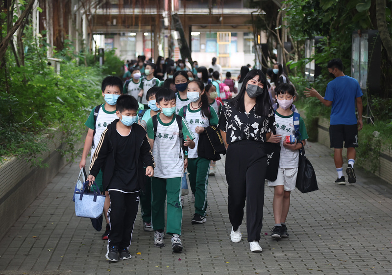 校園口罩令今起鬆綁，但校內健康中心和校車等仍需配戴。圖為台北市信義區永春國小學生午後開心放學。 (圖：中央社)