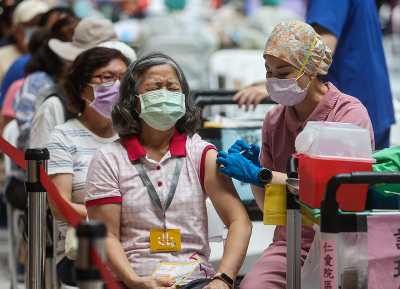 衛福部表示，本土疫情已過高峰， 逐漸下降。圖為民眾22日下午前往台北車站疫苗接種站，挽起袖子施打疫苗。 (圖：中央社)