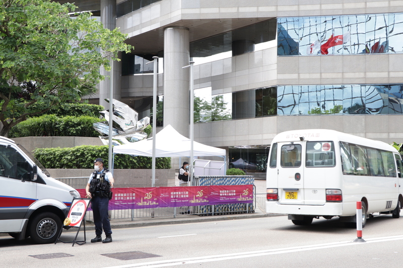 北京領導人習近平預定30日來港出席慶祝回歸活動，香港警方在其活動區高規格布防，圖為警方封鎖灣仔君悅酒店（背景大樓），檢查經過車輛，其旁是即將舉辦慶祝活動的會展中心。 (圖：中央社)