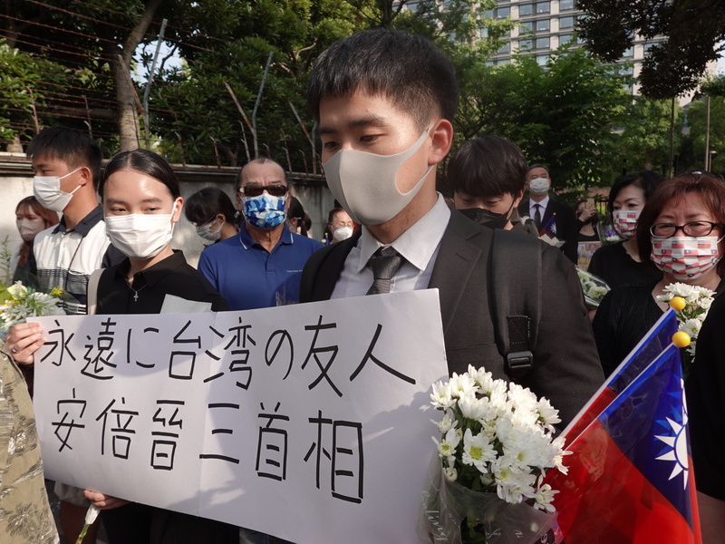 日本前首相安倍晉三8日驟逝，為感念安倍對台灣的友善，一群旅日台灣留學生11日下午到日本執政黨自民黨總部獻花。 (圖：中央社)