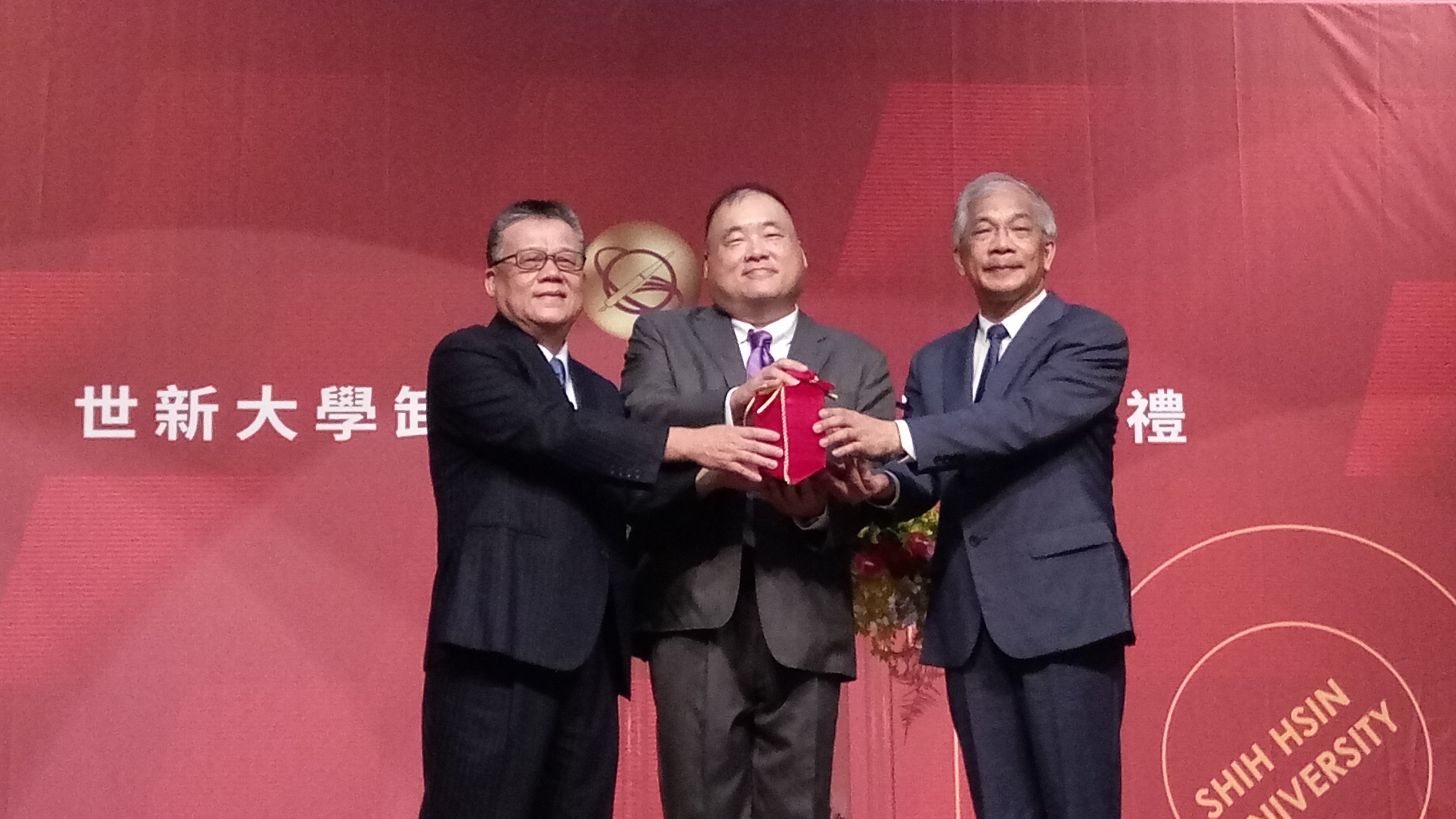 在世新大學董事長周成虎(中)的監交下，吳永乾(左)將印信交接給陳清河(右)。(陳國維 攝)