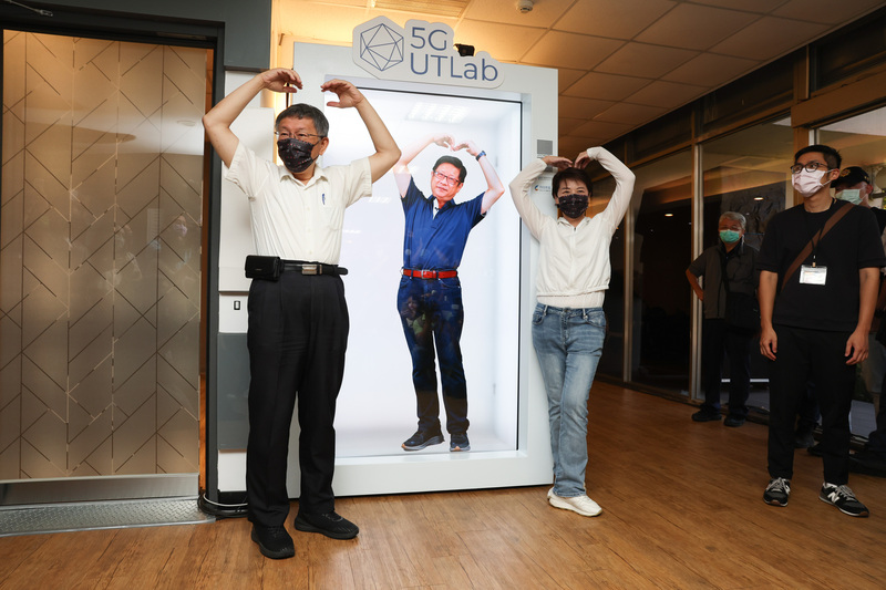 台北市政府產業發展局6日上午舉辦「2022台北新創基地節」開幕活動，產發局長林崇傑（中）透過虛擬實境螢幕與台北市長柯文哲（前左）、副市長黃珊珊（前右2）趣味互動。 (圖：中央社)