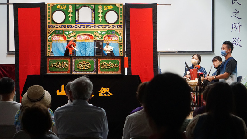 山宛然客家布袋戲團8日在洛杉磯台灣會館演出，樂師歌手於舞台邊現場演奏與演唱。 (圖：中央社)