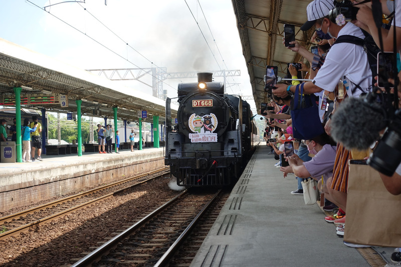 DT668國王號蒸汽火車頭13日上午從扇形車庫開出，緩緩駛入彰化火車站月台，遊客們擠在月台上搶拍留念。(圖：中央社)