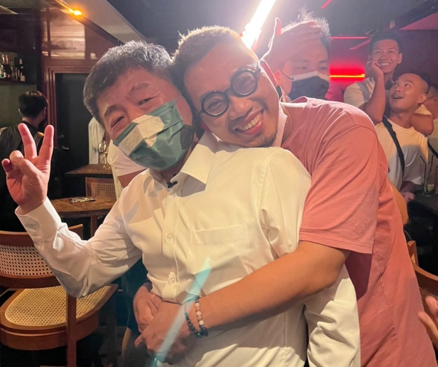 民進黨台北市長參選人陳時中(圖左)24日夜訪北市特色酒吧，熱情年輕人直接「抱緊處理」。(陳時中臉書)
