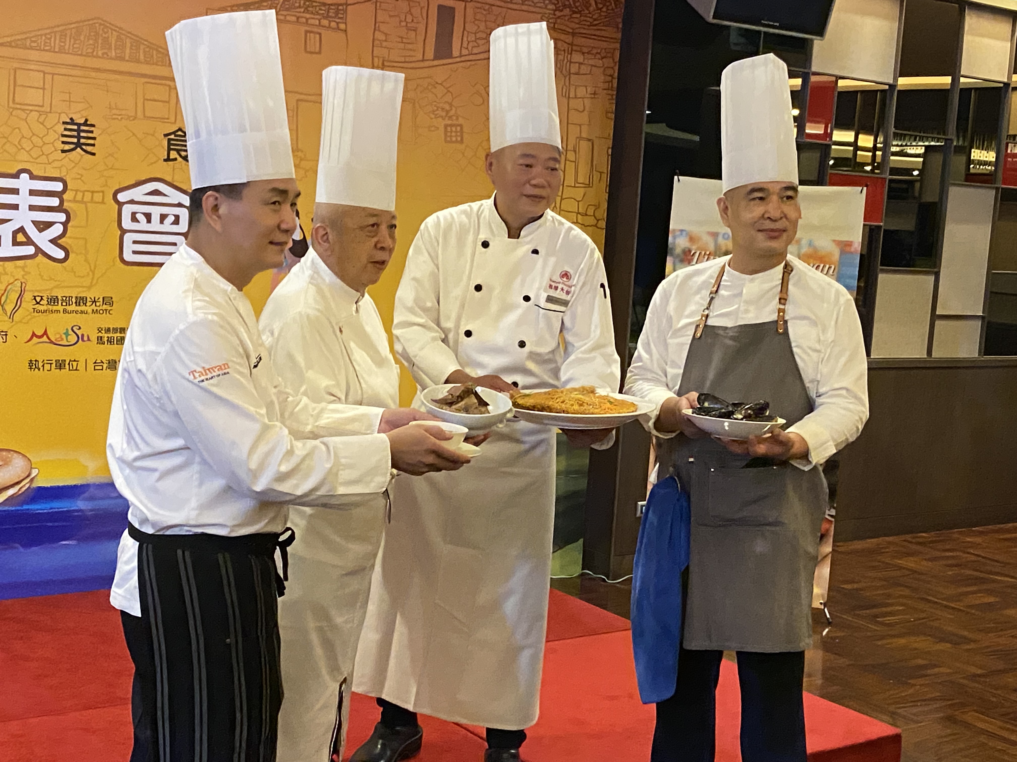 左起陳永華主廚端出現場示範的「紅麴牛肉湯」、陳兆麟主廚示範的「當歸鴨腿佐魚麵」、王永宗主廚示範的「蜂巢海鮮」及陳玉彬主廚示範的「橄欖蒜香淡菜(佐馬祖囍餅)」。(吳琍君攝)