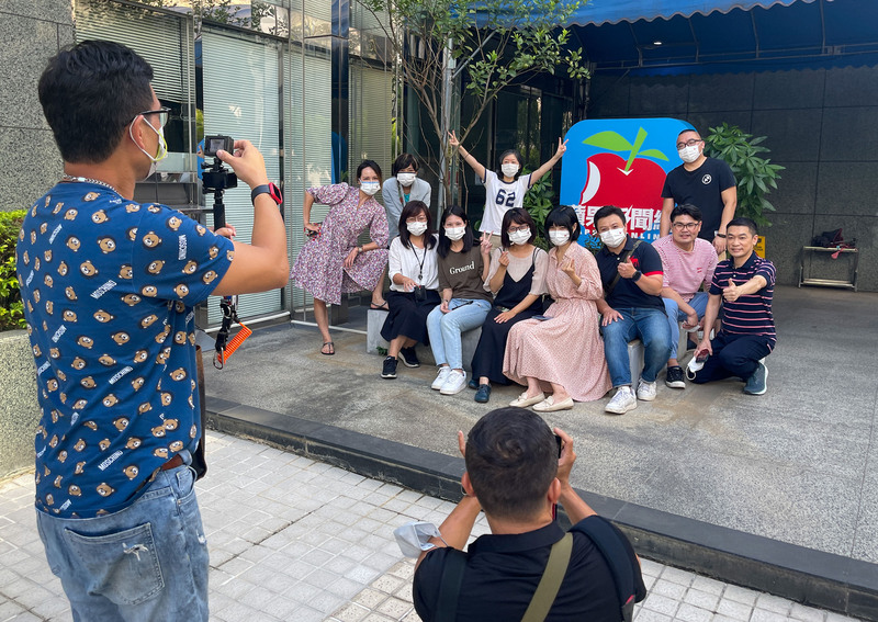 台灣蘋果新聞網31日午夜暫停更新，為19年歷史畫下句點。圖為台蘋員工31日下午在台北市內湖區辦公大樓前和蘋果新聞網招牌合影留念。(圖：中央社)