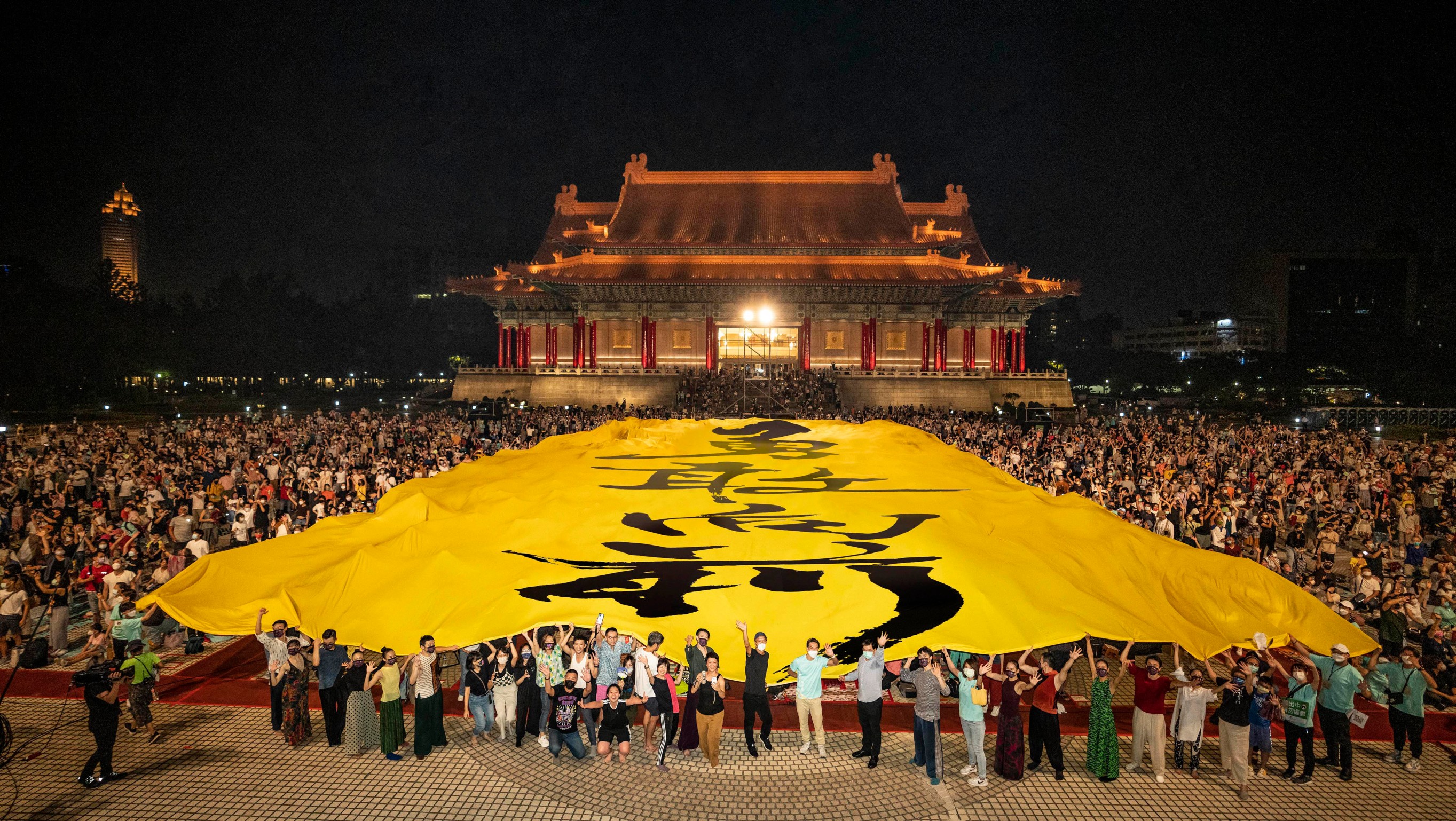 雲門舞集17日晚間在兩廳院舉辦戶外公演，表演尾聲，現場更拉起「勇敢向前」巨幅布條，希望為大家帶來繼續向前的勇氣！（劉振祥攝／雲門舞集提供）