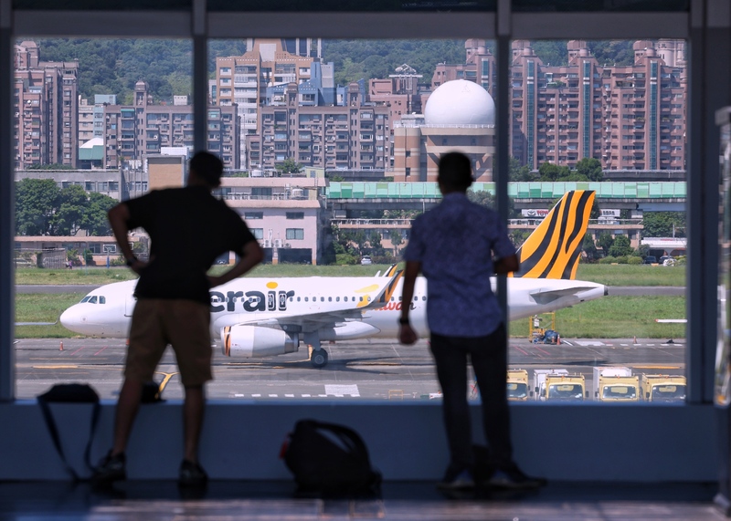 邊境分階段解封，行政院長蘇貞昌22日表示，入境「0+7」制度預計10月13日上路，同時也將開放免簽證國家入境、取消觀光禁團令等。圖為台北松山機場，民眾在觀景台觀賞飛機起降。 (圖：中央社)