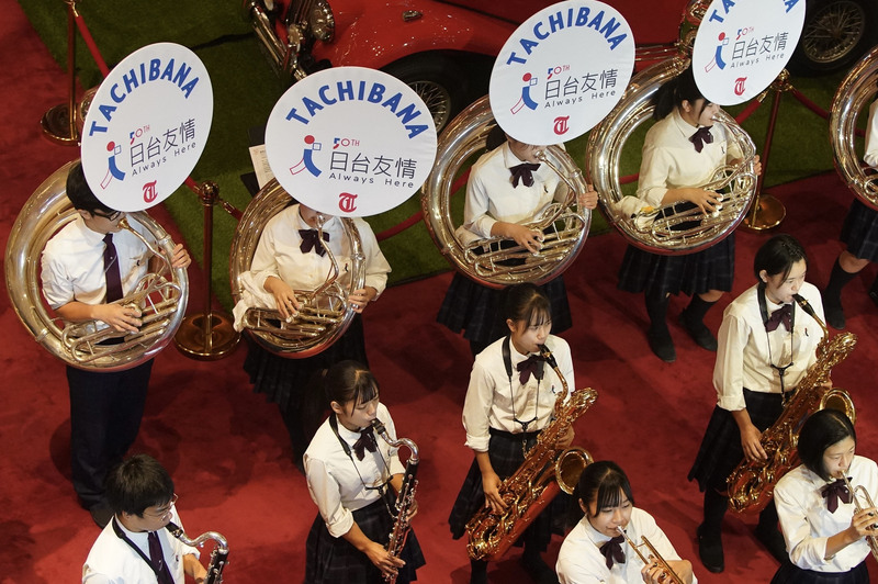 日本京都橘高校吹奏部學生6日在台北圓山大飯店大廳快閃演出，學生的樂器掛上「日台友情」的牌子。 (圖：中央社)
