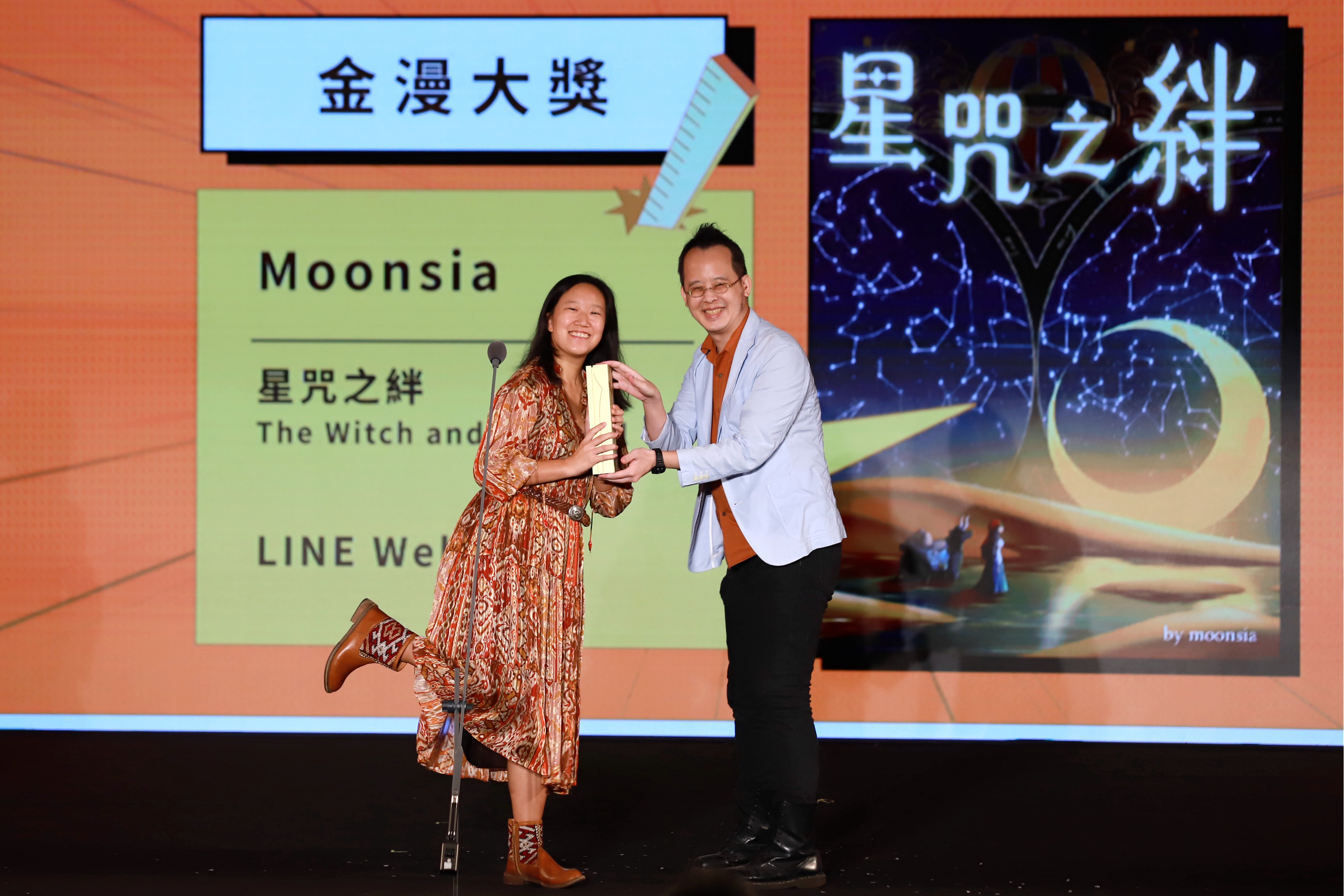 頒獎人李隆杰(右)頒發「金漫大獎」獎座給Moonsia(左)。(文化部提供)