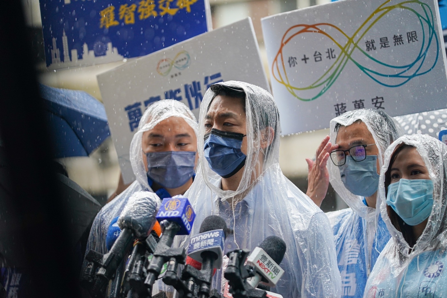 國民黨台北市長參選人蔣萬安7日冒雨陪同3位國民黨市議員參選人在路口拜票。(蔣萬安競辦提供)