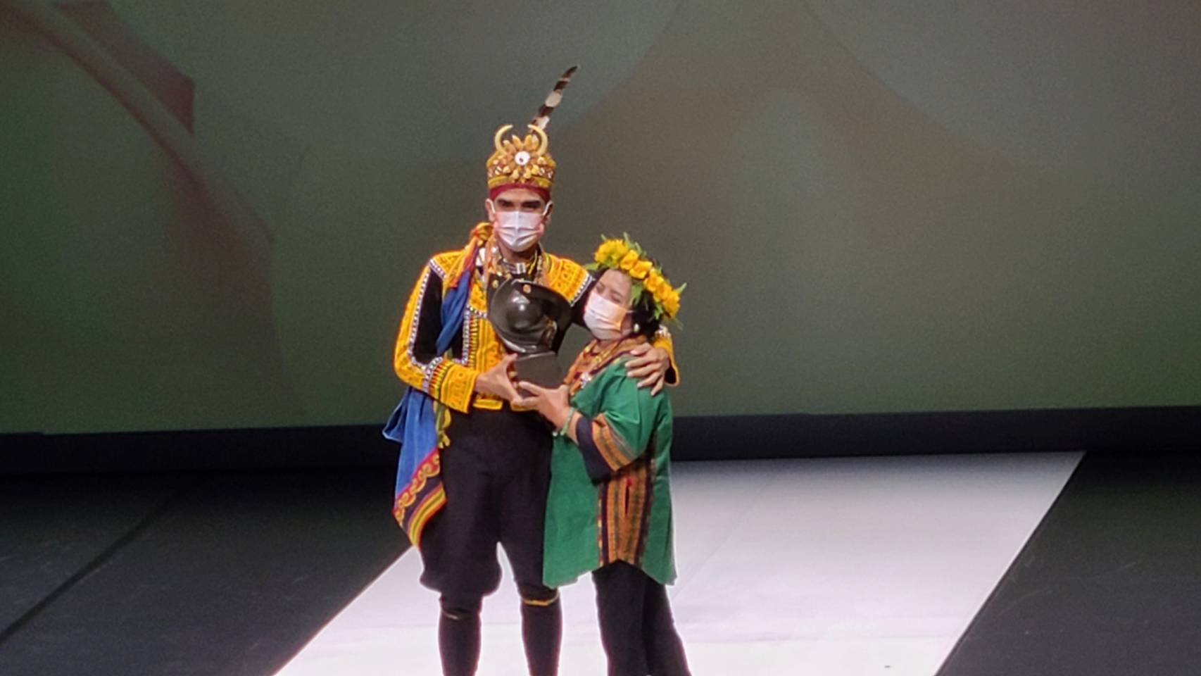 第22屆國家文藝獎舞蹈類得主為排灣族編舞家布拉瑞揚・帕格勒法(左)，他母親親自贈獎，並為其穿上家族族服，戴上父親的頭冠。(江昭倫攝)