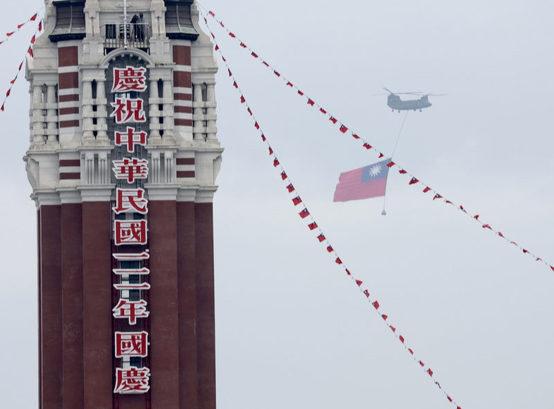 學者認為，蔡英文總統雙十國慶談話拋出願與北京尋找和平穩定方法是再度對北京釋放善意。圖為CH-47契努克運輸直升機吊掛巨幅國旗，繞行總統府前上空。 (圖：中央社)