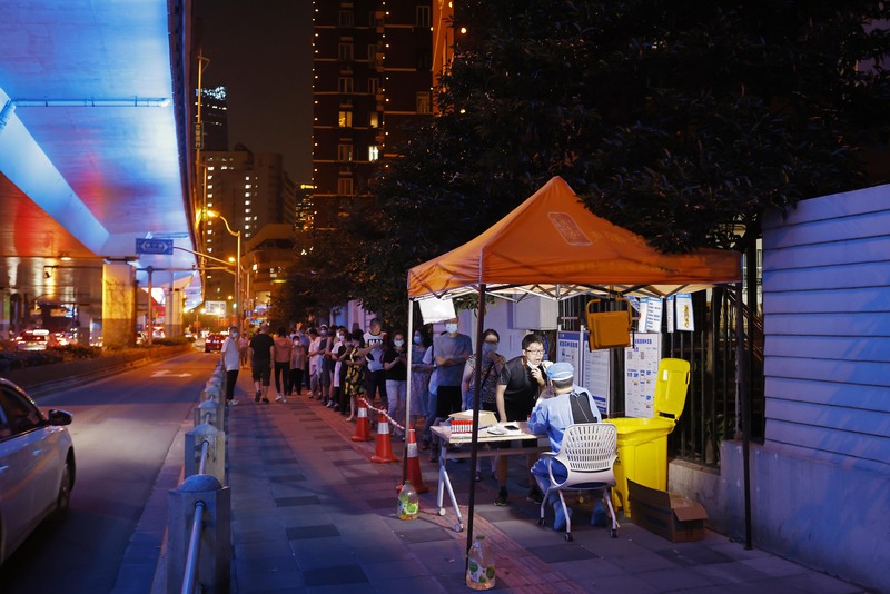 中共官媒人民日報11日發文強調「動態清零可持續而且必須堅持」，遭到網友一面倒痛批後，微博急降熱搜冷卻討論。圖為2日，上海長寧區，民眾入夜排長龍接受核酸檢測。（中新社提供） (圖：中央社)