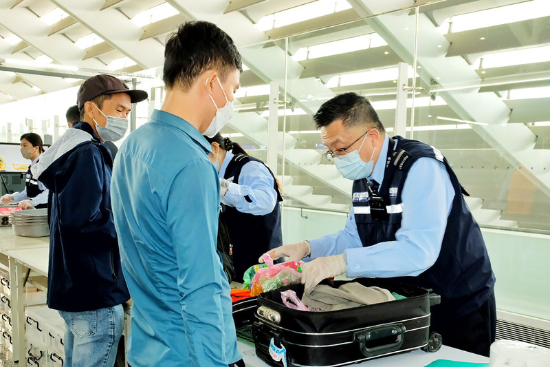 桃園國際機場邊境檢疫業務，機場工作人員針對旅客行李開箱檢查。(圖：中央社)