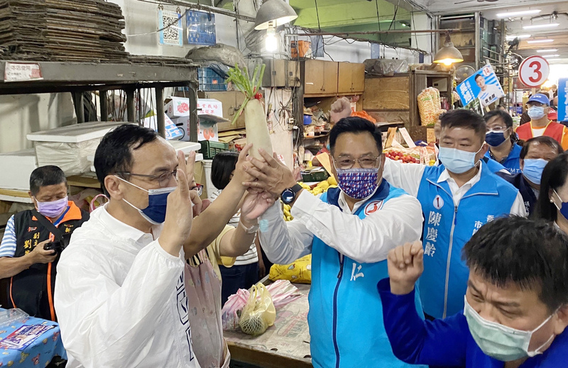 國民黨主席朱立倫（前左）2日陪同國民黨新竹市長參選人林耕仁（前左2）到市場拜票，獲得攤商贈送白蘿蔔，象徵「好彩頭」。 (圖：中央社)