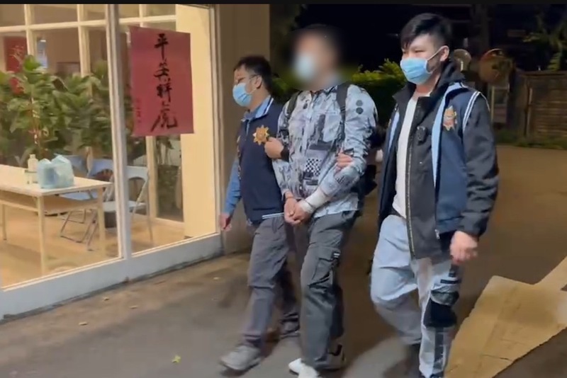 新北警方日前破獲囚禁凌虐受害者的詐騙集團，在新北淡水與桃園中壢共救出58人，各逮獲8名嫌犯；警方4日深夜在桃園市龜山區再逮捕1名35歲陳姓嫌犯（中）到案。（翻攝照片） (圖：中央社)