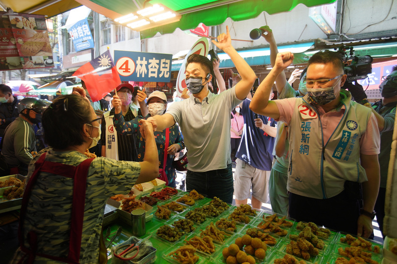 國民黨台北市長候選人蔣萬安（中）10日上午前往北投自強市場掃街拜票，向民眾尋求支持，衝刺選情。(圖：中央社)