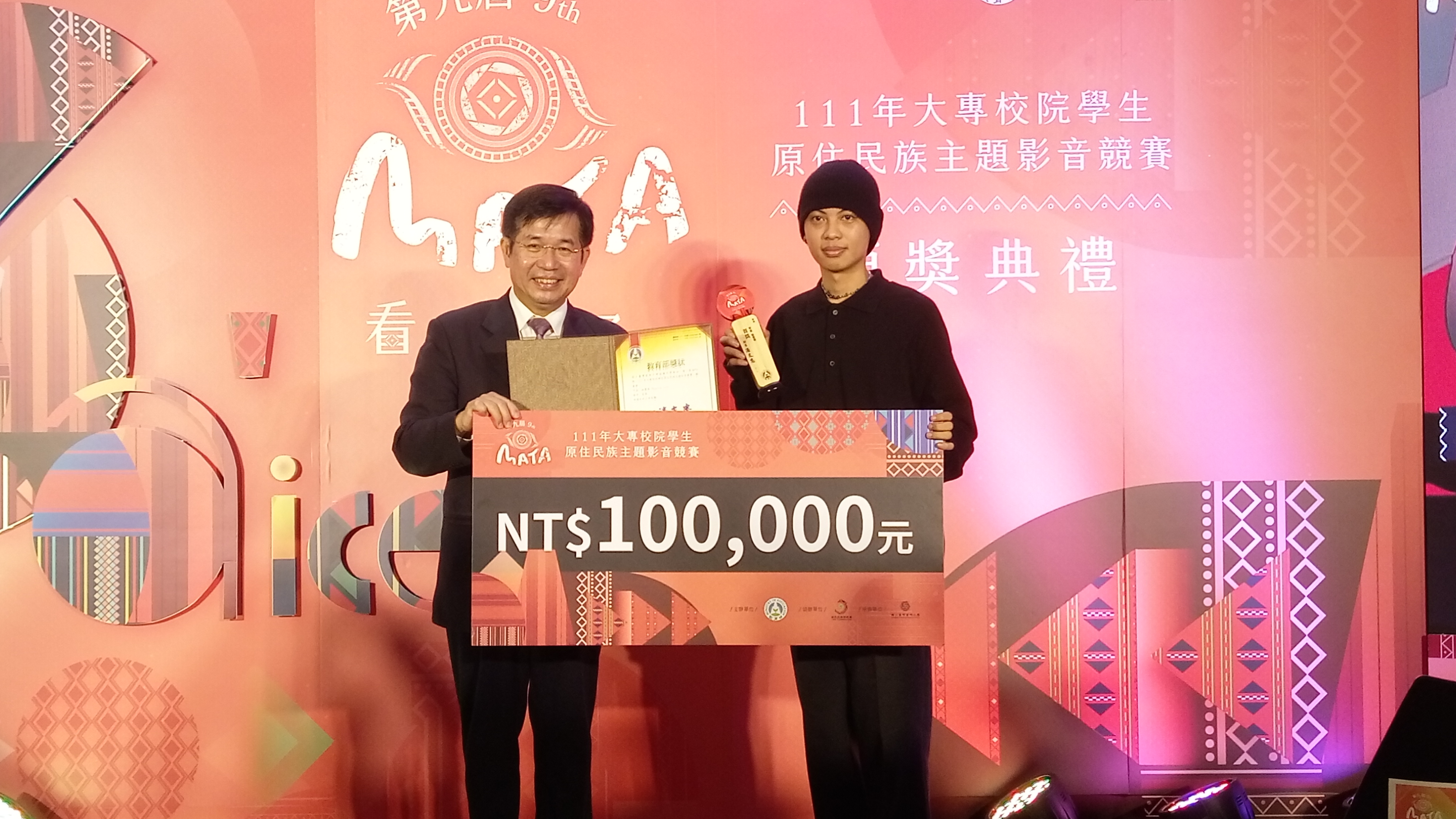 教育部長潘文忠(左)頒發獎座與10萬元獎金給台灣藝術大學學生施謙(右)。(陳國維 攝)