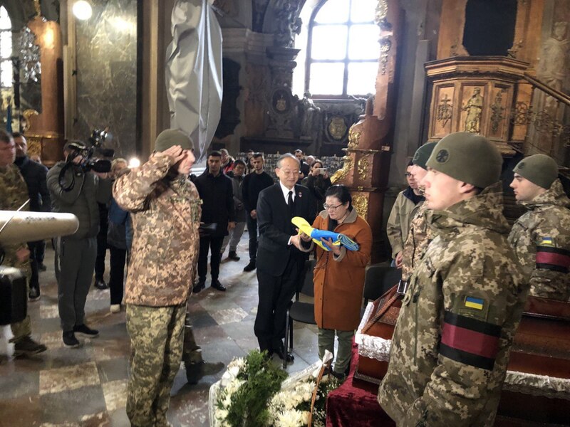 曾聖光戰死烏克蘭，烏國軍方今天舉辦追思儀式，軍方代表向曾聖光致敬，駐波蘭代表陳龍錦（黑色西裝者）全程陪同家屬。（外交部提供）(圖：中央社)