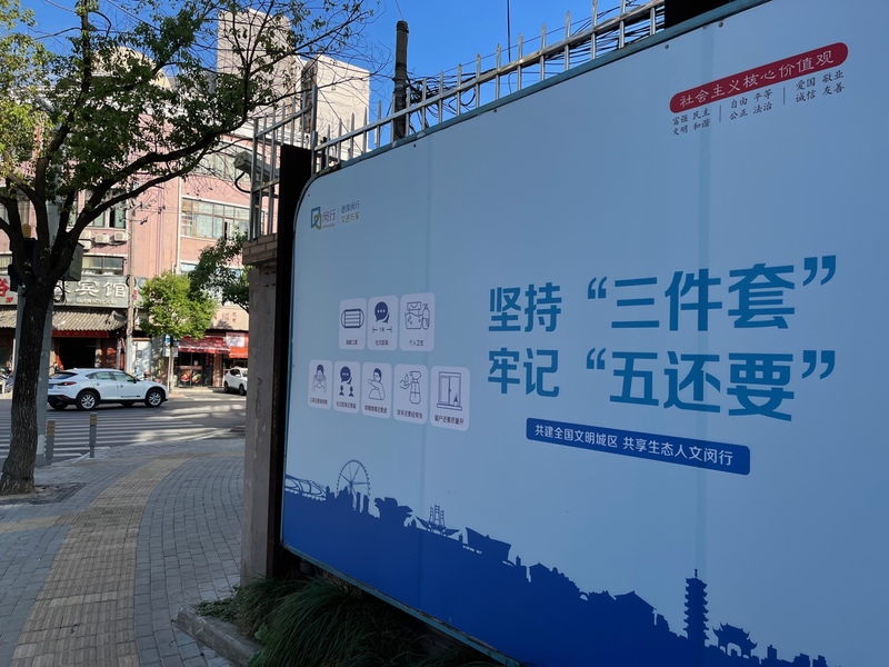 圖為上海街頭防疫宣傳看板。「三件套」所指的是，佩戴口罩、保持社交距離、注意個人衛生；「五還要」則是口罩還要戴、社交距離還要留、咳嗽噴嚏還要遮、雙手還要經常洗、窗戶還要盡量開。(資料照片/CNA)
