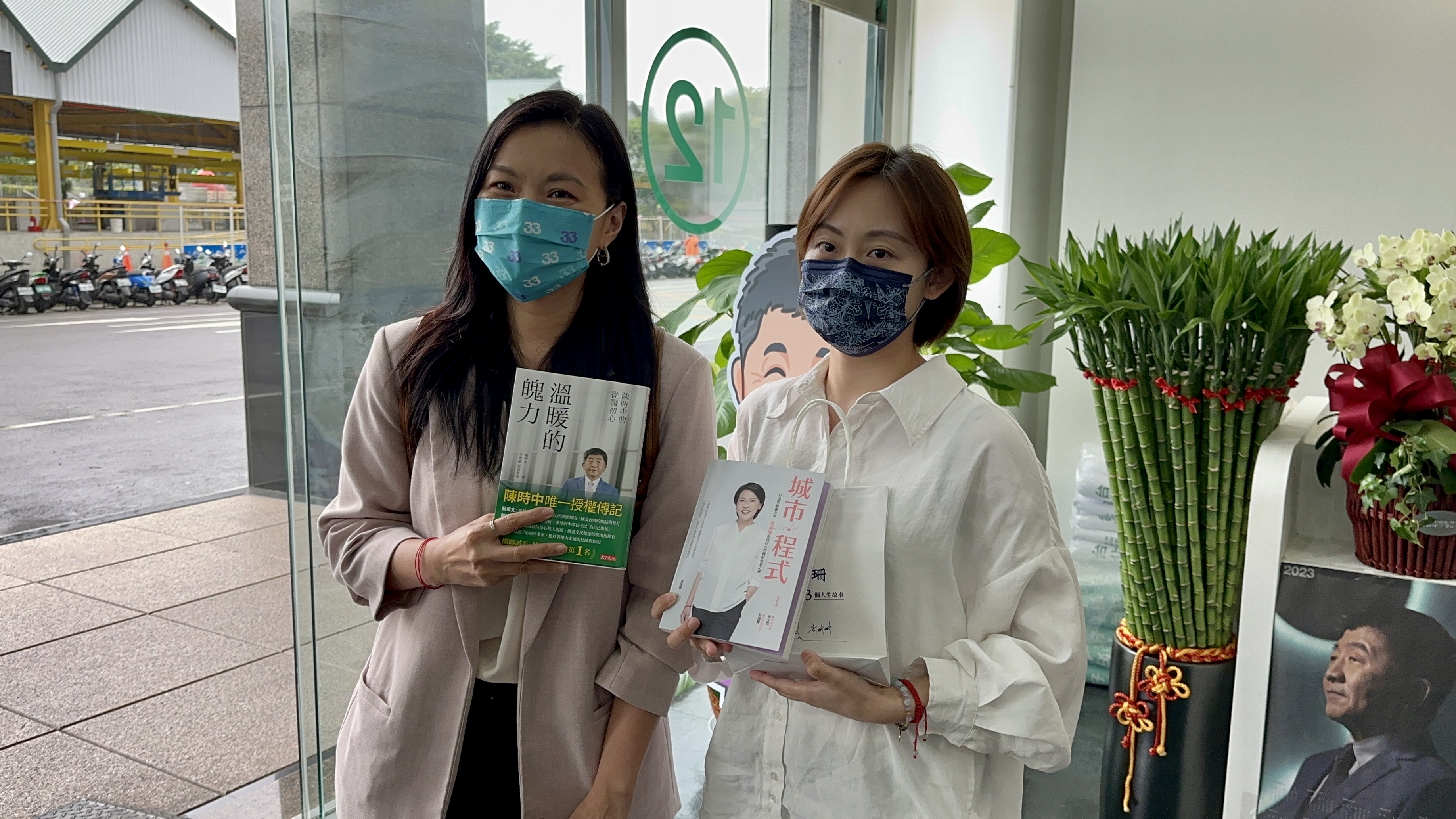 黃珊珊競辦發言人李昀臻(左)及陳時中競總發言人林聿禪(右)互贈黃珊珊及陳時中的書籍。(黃珊珊競總提供)