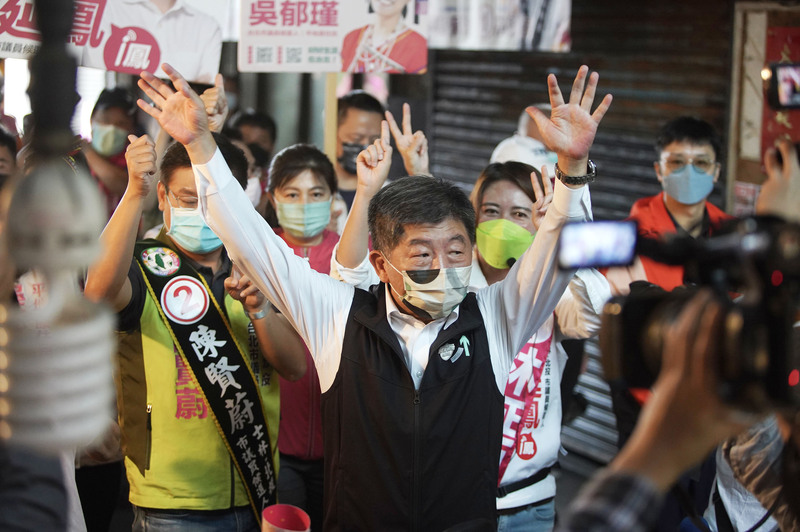 民進黨台北市長候選人陳時中（中）18日上午赴士林區葫蘆堵市場掃街拜票，高舉雙手向民眾致意，爭取支持。 (圖：中央社)