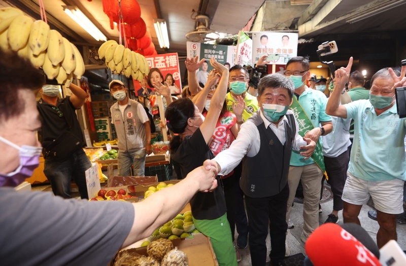 民進黨台北市長候選人陳時中(前中)20日在湖光市場掃街拜票，支持的民眾在旁高喊「凍蒜」。(圖：中央社)