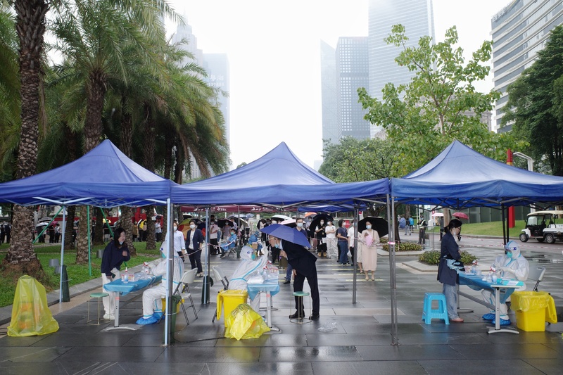 圖為22日，疫情嚴重的廣州市，民眾冒雨排隊接受核酸檢測。(中新社提供)(圖：中央社)