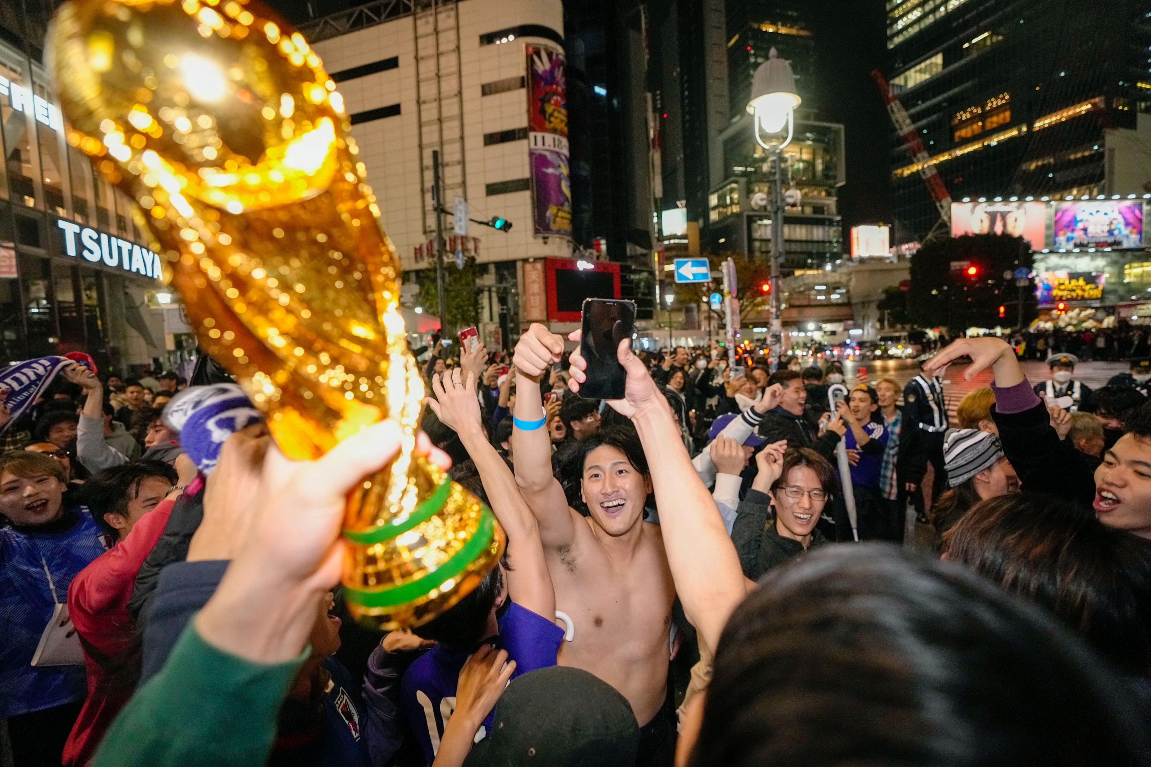 日本球迷23日在東京澀谷慶祝贏球。(路透社/達志影像)