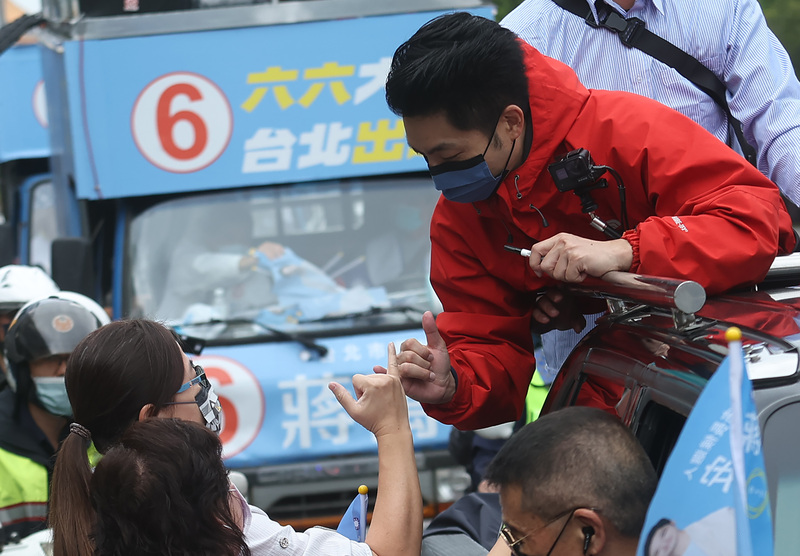 國民黨台北市長候選人蔣萬安（右，紅外套）25日進行「萬安台北出運行 約定1126投票去」12區掃街拜票。 (圖：中央社)