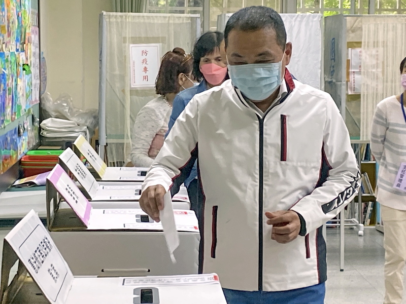 國民黨新北市長候選人侯友宜（前）26日前往新北市板橋區板橋國小投票，並感謝選務人員的辛勞。 (圖：中央社)