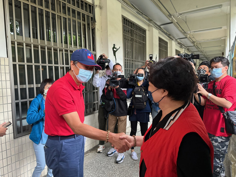 鴻海集團創辦人郭台銘（前左）26日上午前往九合一選舉投開票所投票，與路過民眾握手打招呼。 (圖：中央社)