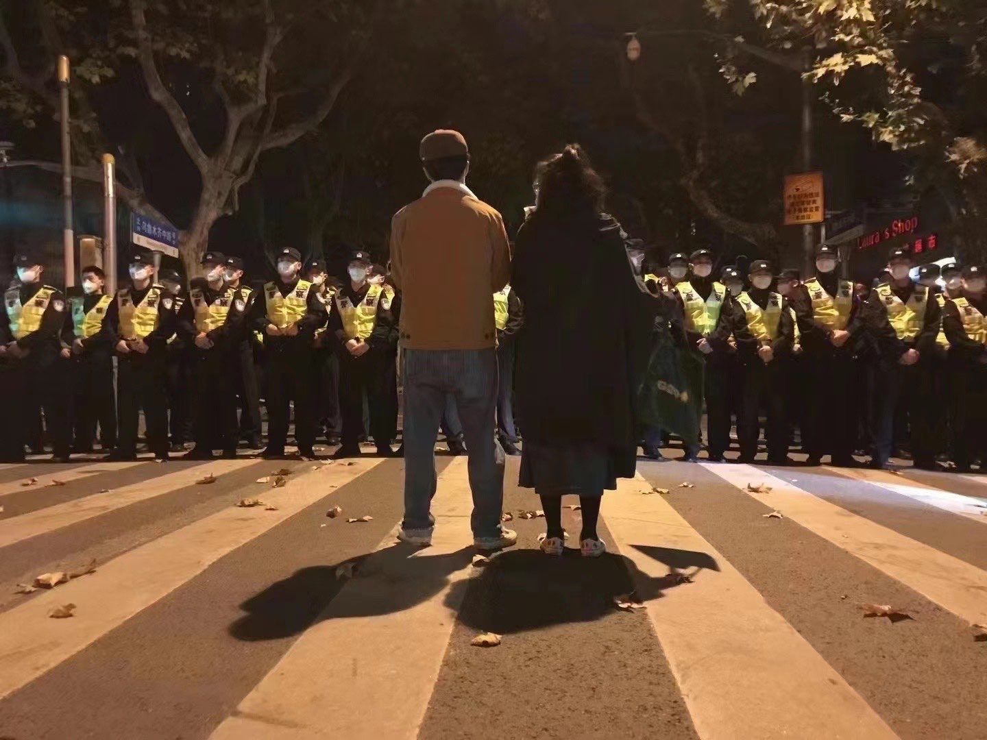 上海爆發反封控示威，兩名上海復旦大學教授站在學生與武警中間，保護學生不受抓捕。(Twitter/@RealBeiMing)