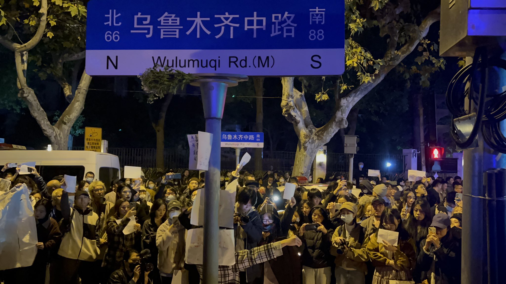 中國白紙運動屆滿周年，有當時參與運動民眾將參與過程拍攝成紀錄片，控訴中國政府鎮壓。圖為2022年11月間上海烏魯木齊中路悼念烏魯木齊火災死難者所進行的反封控示威。(Twitter)