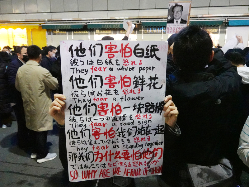旅日的中國年輕人人11月30日晚間在東京新宿車站前聲援白紙運動，高喊「國賊習近平下台！不要封控要自由！」 (圖：中央社)