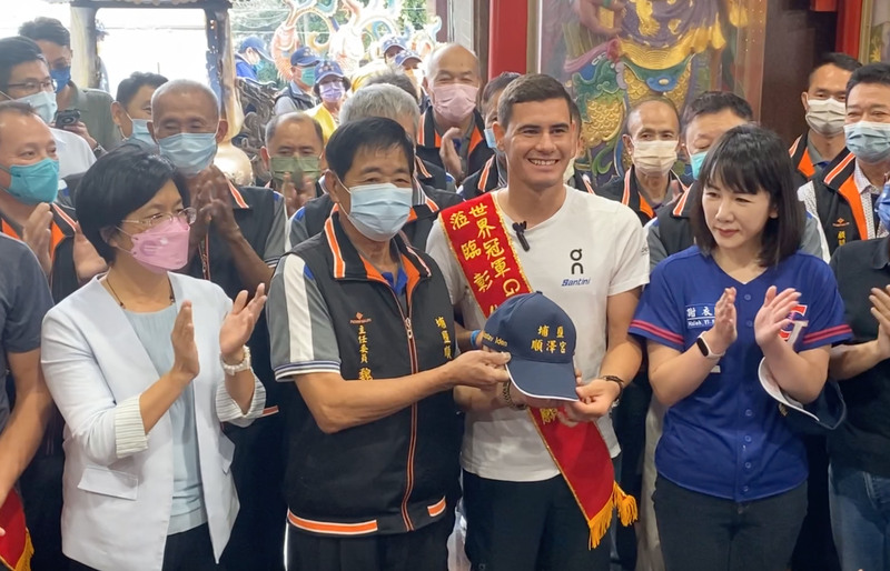 挪威三鐵好手艾登（Gustav Iden）（前右2）來台訪問，4日到彰化縣埔鹽鄉順澤宮還願，順澤宮管理委員會主任委員魏信顧（前左2）特別贈送新版印有「台灣」字樣的冠軍帽給艾登，祝福他比賽順利。 (圖：中央社)