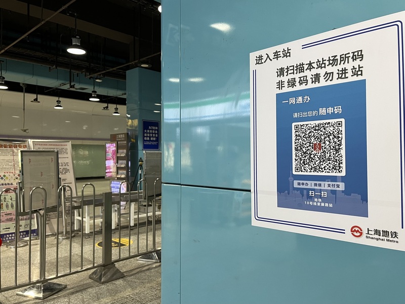 上海市疫情防控工作領導小組辦公室宣布12月5日零時起，旅客搭乘地鐵、公交等公共交通工具不再查驗核酸檢測證明；旅客進入地鐵站則仍必須掃場所碼、出示綠碼。圖為上海市地鐵站入口處所張貼的場所碼掃碼提醒。(圖：中央社)