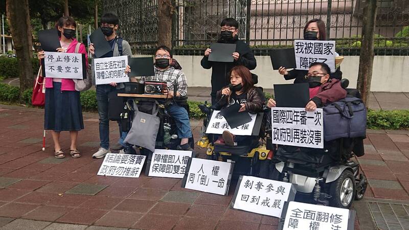 「身心障礙者權益保障法」時隔15年再度修法，障礙者團體不滿未安排聽取表達意見，5日多人在臨時會議外高舉黑紙抗議，象徵把紙寫滿也不被看見。(圖:中央社)