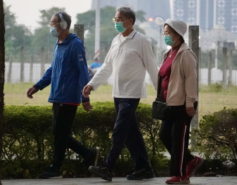 圖為高雄鳳山區顯著降溫，民眾外出運動不忘添衣保暖。(資料照片/CNA)