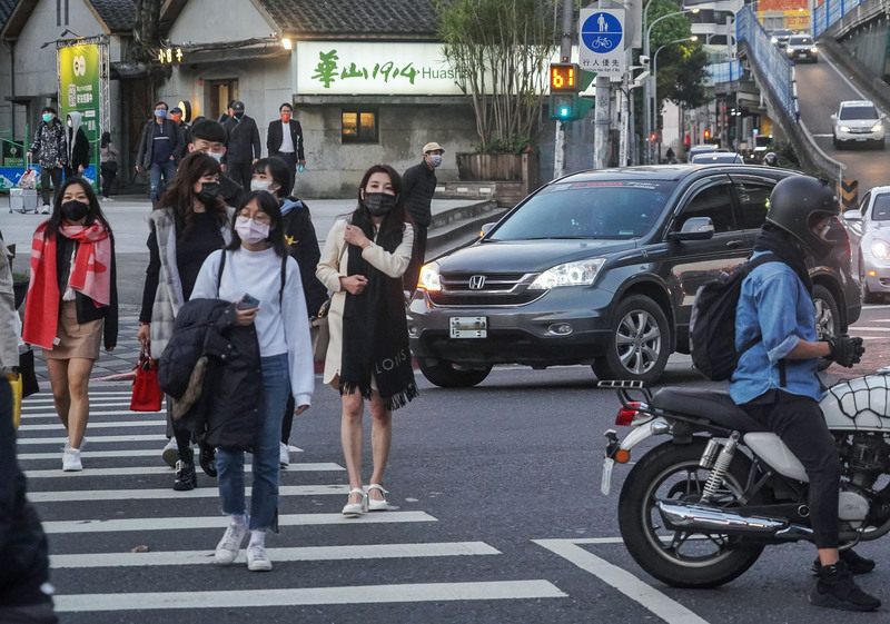 圖為民眾在台北市中正區過馬路，右轉車輛停等禮讓。 (圖：中央社)