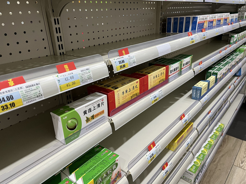 上海市COVID-19疫情持續，退燒藥布洛芬、乙醯氨基酚等藥物供貨仍為不穩，實體藥房負責人表示，目前進貨量仍不算穩定。圖為上海市一家藥房內部陳設，多款退燒藥物來不及供貨或是長期缺貨，留下空蕩貨架。 (圖：中央社)