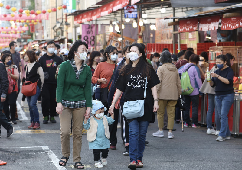 中央流行疫情指揮中心14日公布國內新增20,412例COVID-19確定病例，分別為20,149例本土個案及263例境外移入。圖為民眾戴口罩在台北迪化街逛街。 (圖：中央社)