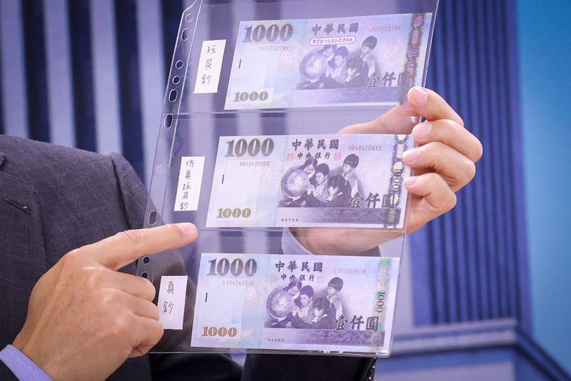 中央銀行17日舉行記者會，出示玩具鈔、仿真玩具鈔與真鈔比對，其中仿真玩具鈔與真鈔頗為相似，提醒民眾多留意。(圖：中央社)